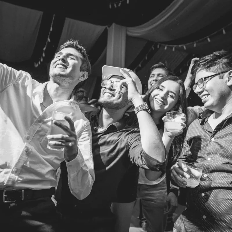 Grupo de invitados brindando y celebrando, fotografía en blanco y negro