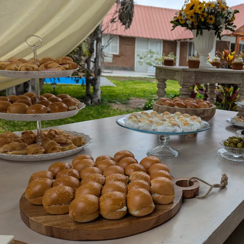 Estación de buffet con panes y bocaditos servida al aire libre