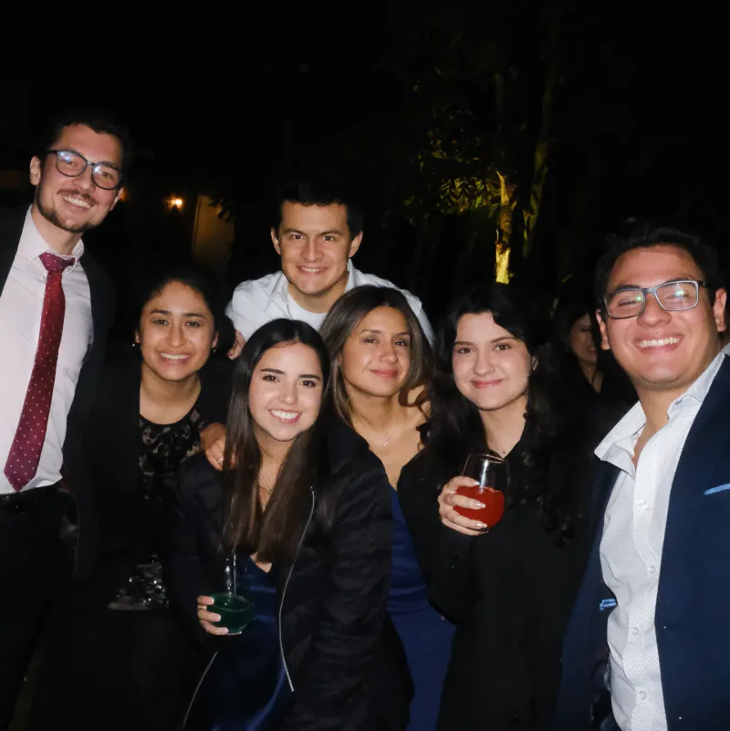 Mobiliario lounge de pallets con cojines blancos sobre el césped, de noche