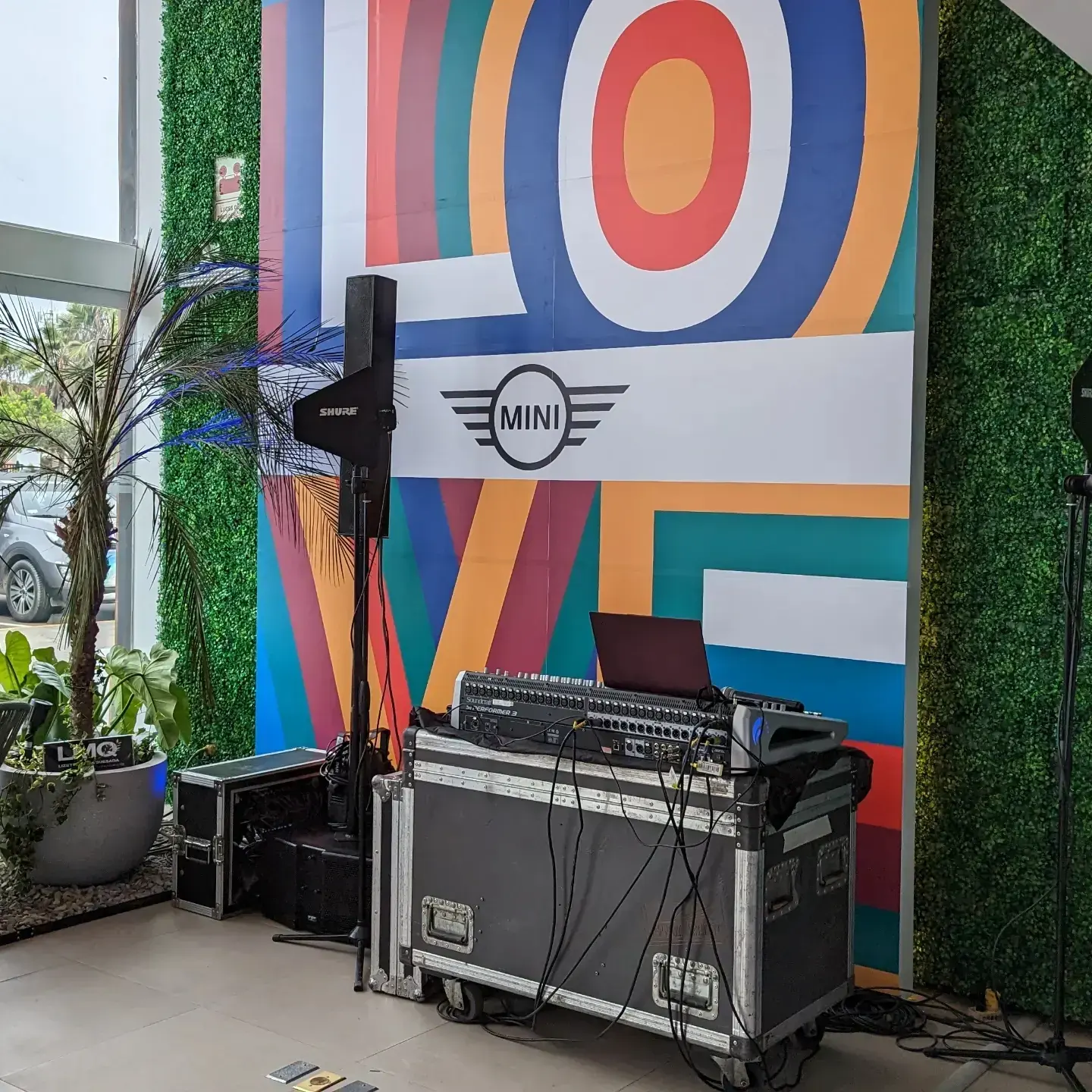 Mural gráfico de colores con el logo de MINI y equipo de sonido montado para la activación