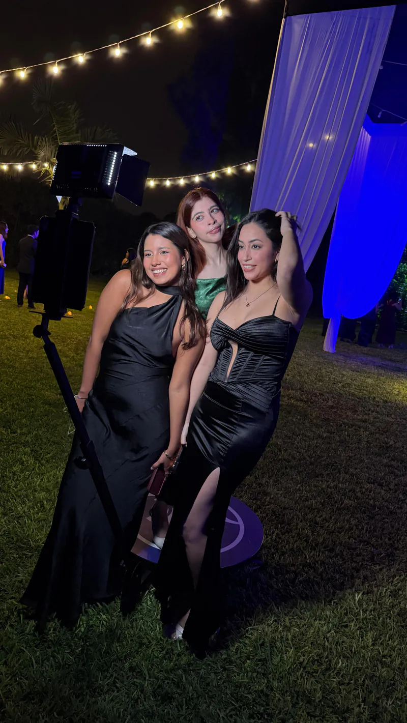 Tres invitadas posando frente a la cámara del photobooth en la fiesta de promoción