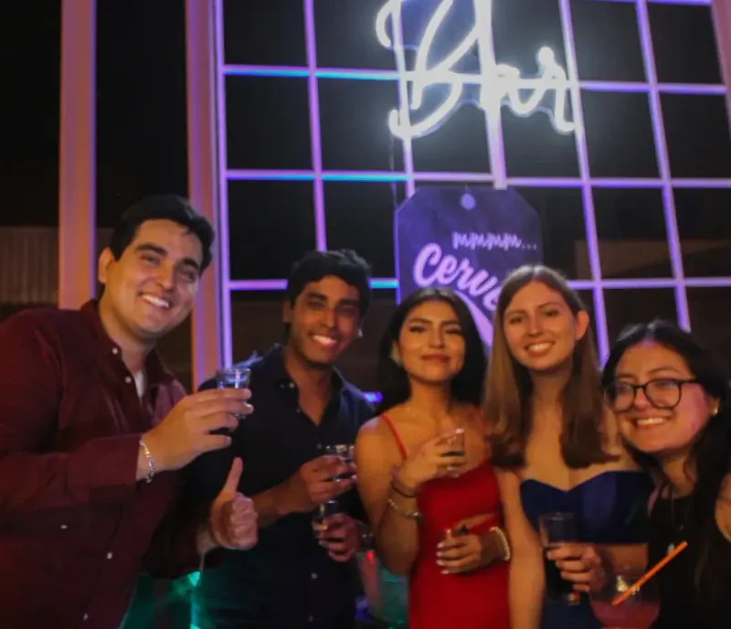 Invitados posando frente a un letrero de neón 